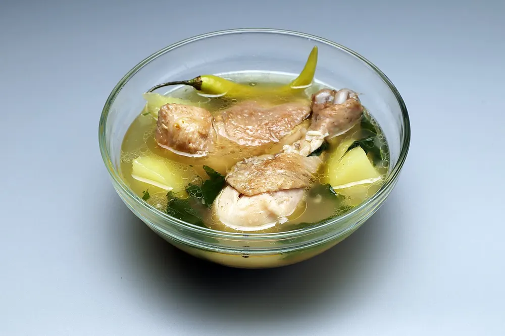 Tinolang manok — clear ginger chicken soup with chayote and chili leaves
