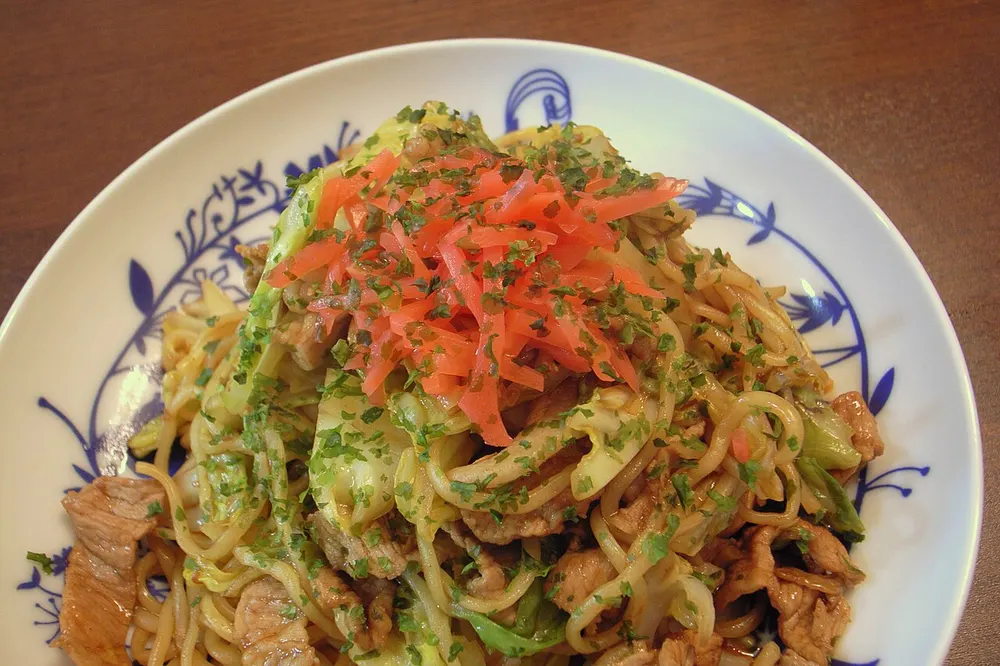 A plate of yakisoba fried noodles with pork and vegetables