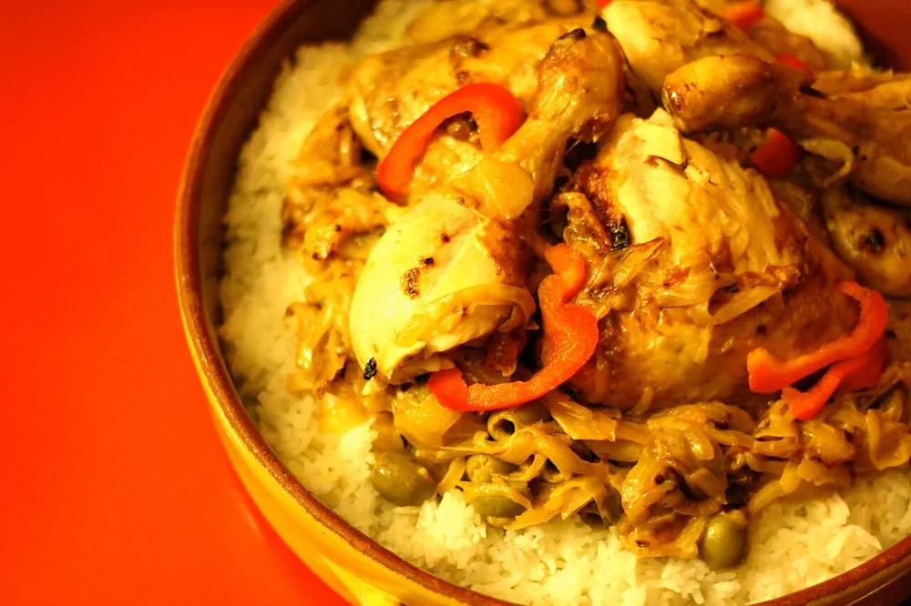Chicken yassa — chicken and softened onions piled over white rice