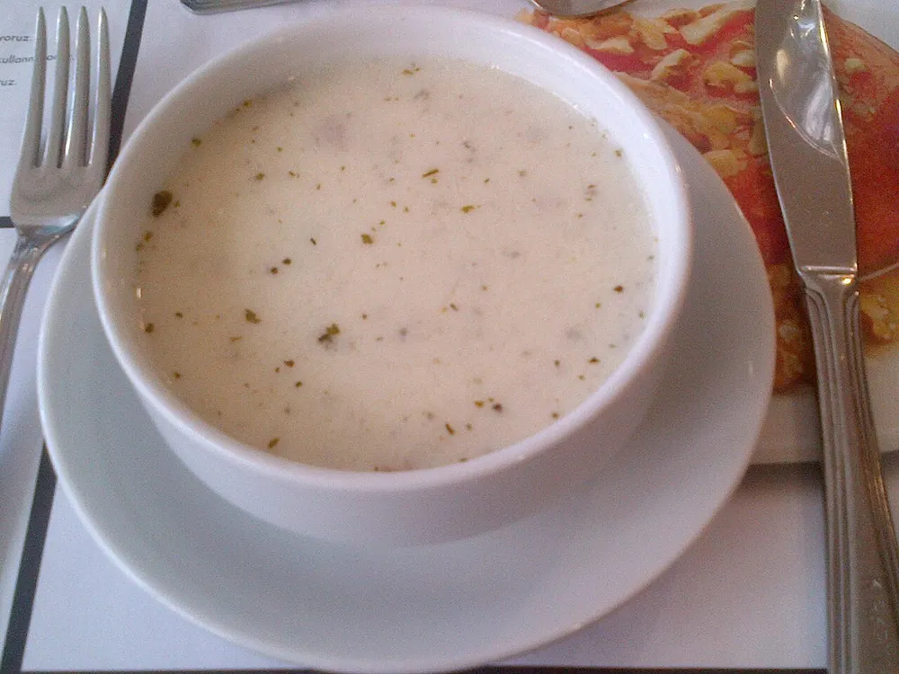 A bowl of white yogurt-and-rice yayla soup with mint